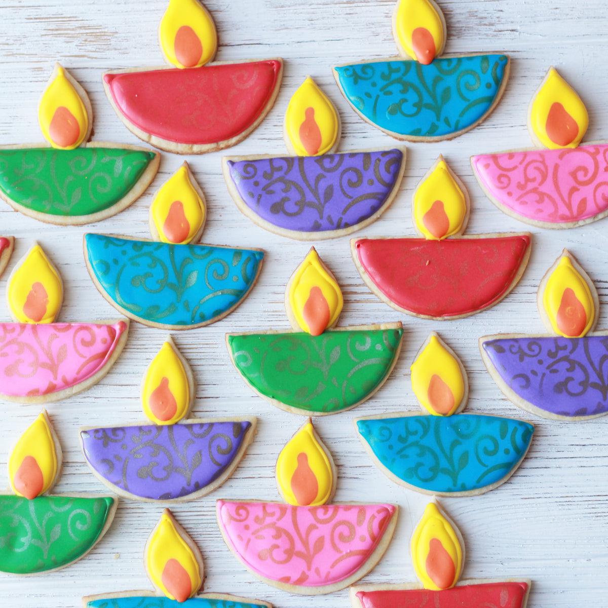 Colorful cookies shaped like Diwali lamps on a white background